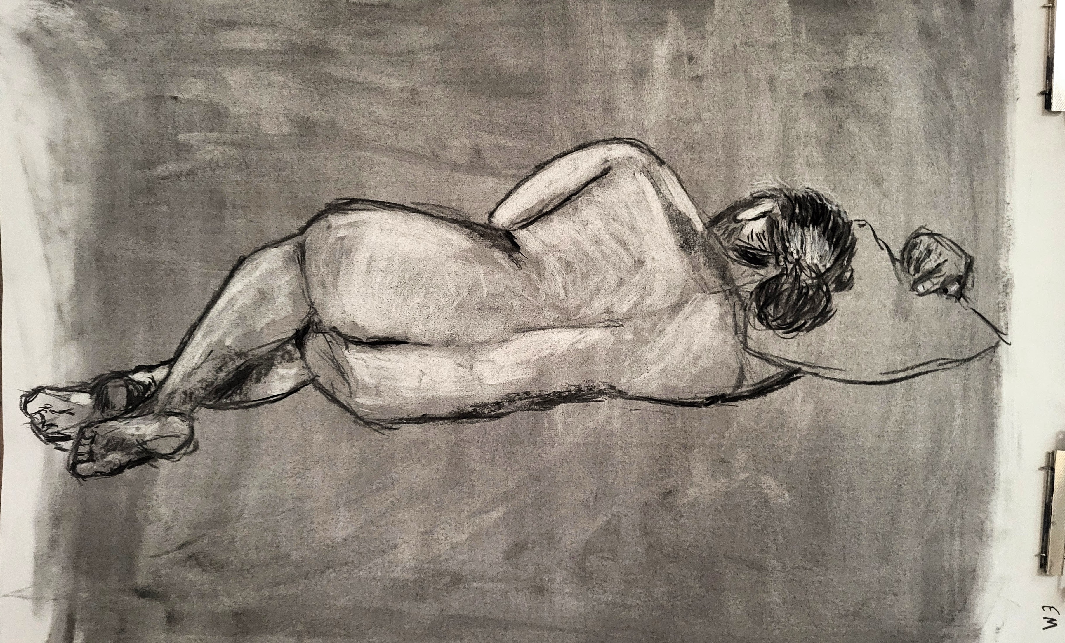 Drawing of a model lying down on his side faced away from me.